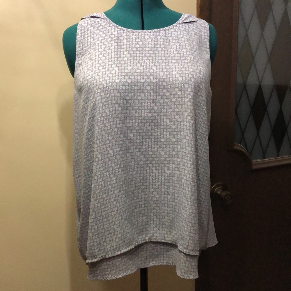 Sleeveless tunic with white and lavender pattern on gray background
